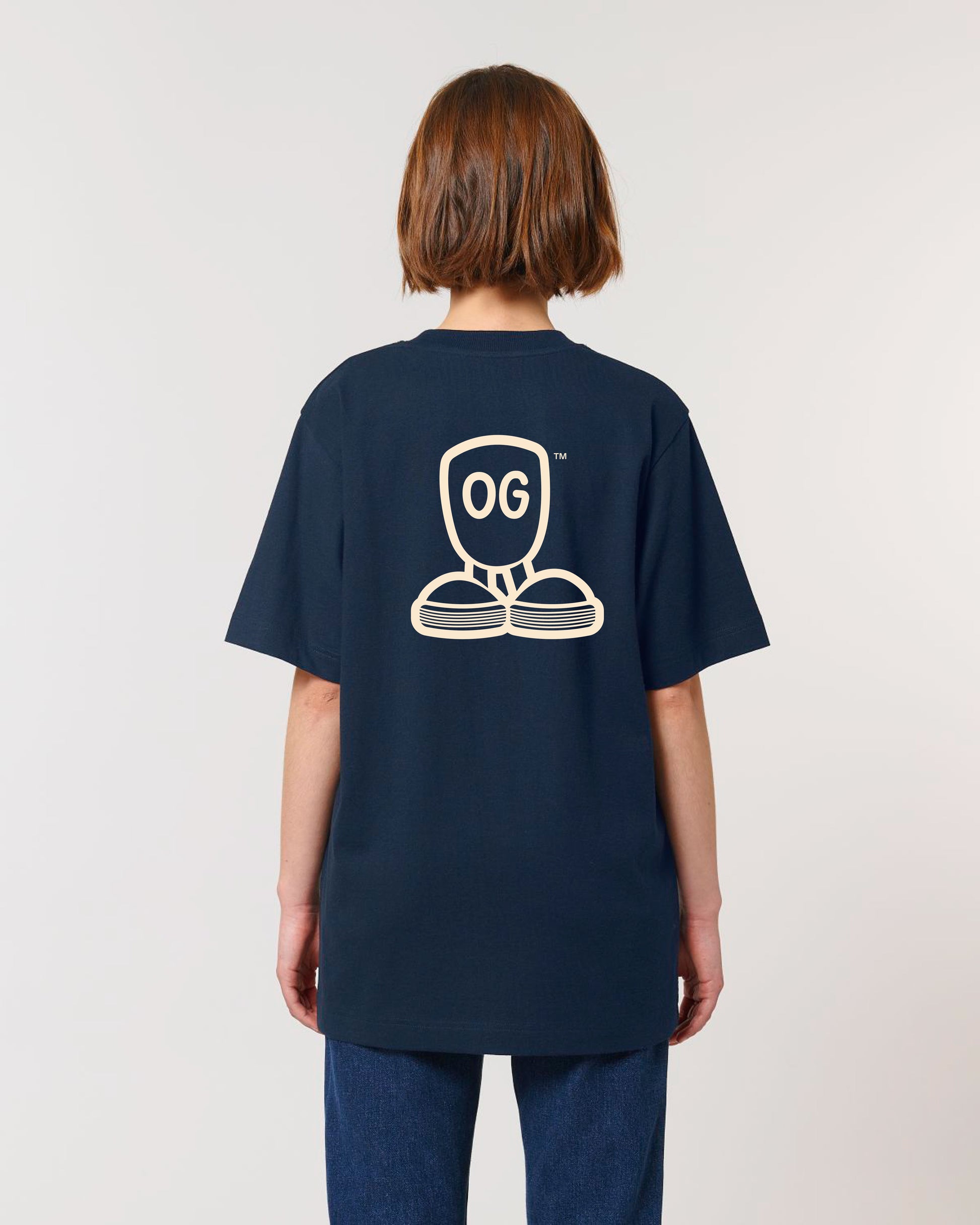 Bagfra visning af mørkeblå T-shirt med stort hvidt OG-logo og grafisk design på ryggen, båret af person med kort hår og mørkeblå jeans. Billedet fremhæver ryggrafikken og T-shirtens street-inspirerede stil i en casual pasform, perfekt til en afslappet og stilbevidst garderobe.